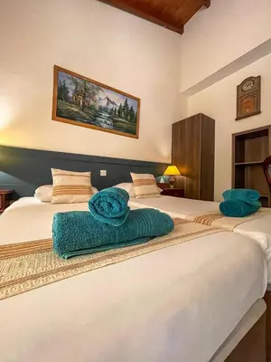 two beds in a room with two blue towels on them at DownTown Studios & Two-Bedrooms in Larnaka
