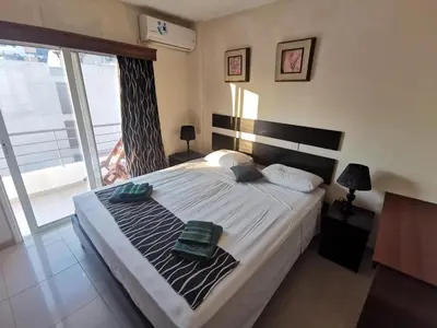 a bedroom with a large bed with a large window at DownTown Studios & Two-Bedrooms in Larnaka