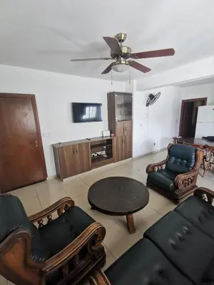 a living room with a table and chairs and a ceiling fan at DownTown Studios & Two-Bedrooms in Larnaka