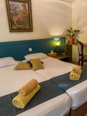 a hotel room with two beds with towels on them at DownTown Studios & Two-Bedrooms in Larnaka