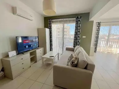 a living room with a couch and a flat screen tv at Thaleia Suite - Tourism License 3119 in Protaras