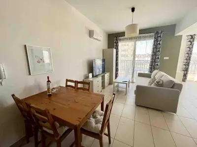 a living room with a table and a couch at Thaleia Suite - Tourism License 3119 in Protaras