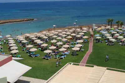 a group of chairs and umbrellas on a beach at Thaleia Suite - Tourism License 3119 in Protaras