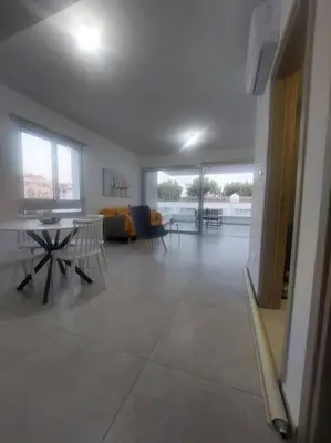 a large living room with a table and chairs at Luxury 2 bedroom apartment in Larnaka