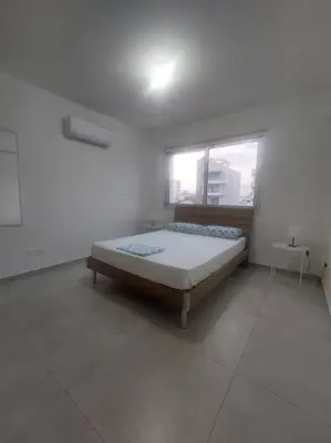 a white room with a bed and a window at Luxury 2 bedroom apartment in Larnaka