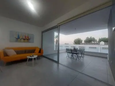 a living room with a couch and a table and chairs at Luxury 2 bedroom apartment in Larnaka