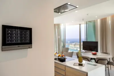 a living room with a tv on a wall at Ayia Napa Marina East Tower Suite in Ayia Napa