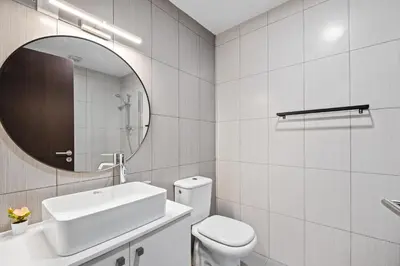 a bathroom with a toilet and a sink and a mirror at Paradise Apartment with Private Pool & Sea View in Larnaka