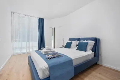 a bedroom with a blue and white bed and a window at Paradise Apartment with Private Pool & Sea View in Larnaka
