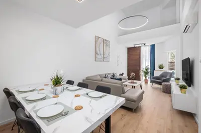 a living room with a large white table and chairs at Paradise Apartment with Private Pool & Sea View in Larnaka