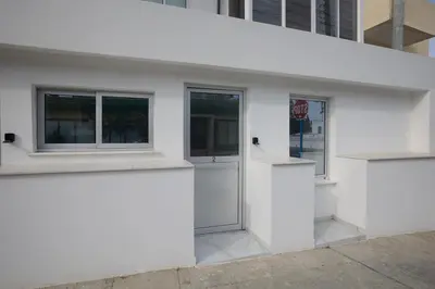 a white building with two windows and a door at Gold Emerging Villas Ltd Apart 2 in Ayia Napa