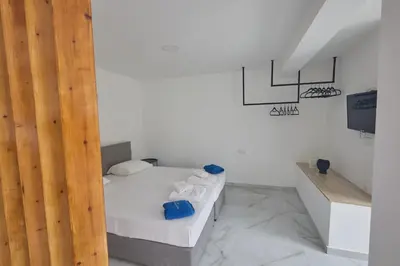 a white room with a bed and a television at Gold Emerging Villas Ltd Apart 2 in Ayia Napa