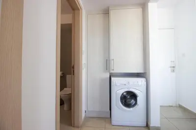 a white washer and dryer in a small bathroom at Beachside 1-bed with huge veranda in Protaras