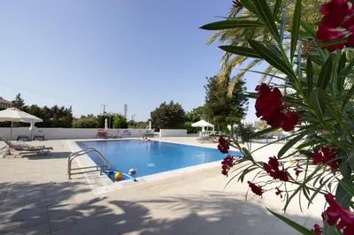 a swimming pool in a resort with pink flowers at Beachside 1-bed with huge veranda in Protaras