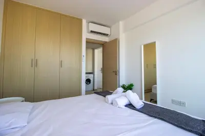 a bedroom with a large white bed with two towels at Beachside 1-bed with huge veranda in Protaras