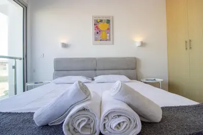 a bedroom with a bed with white towels on it at Beachside 1-bed with huge veranda in Protaras