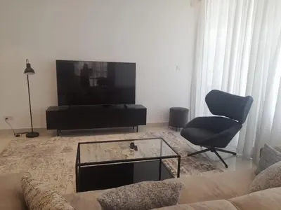 a living room with a couch and a tv and a chair at 360 Building - City View 2 Bedroom Residence in Nicosia