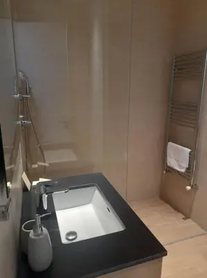 a bathroom with a sink with a black counter top at 360 Nicosia-2 Bedroom City Tower in Nicosia