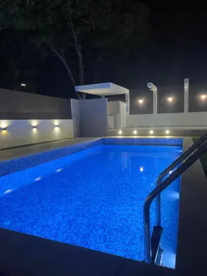 a swimming pool at night with lights on it at Pervolia Oasis Villa in Kiti