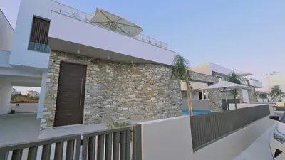 a house with a stone wall and a balcony at STAY Oasis Luxury Villas in Ayia Napa