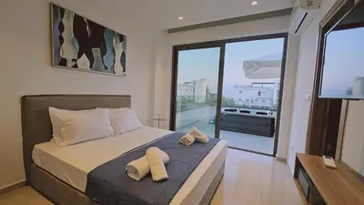 a bedroom with a bed with two towels on it at STAY Oasis Luxury Villas in Ayia Napa