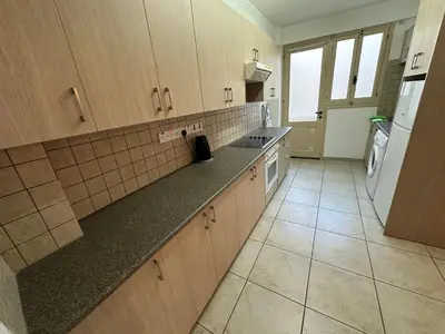 a kitchen with wooden cabinets and a counter top at city center accommodation in Nicosia