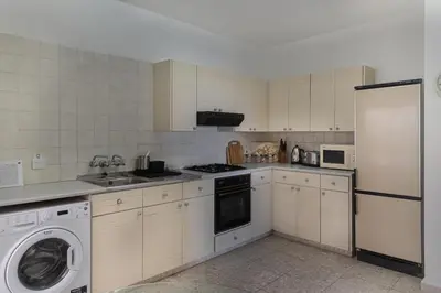 a kitchen with white appliances and a washer and dryer at Phaedrus Living Seaview Phinikoudes Flat in Larnaka
