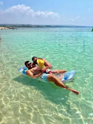 two men laying on a raft in the water at Apartment Veronika in Paralimni