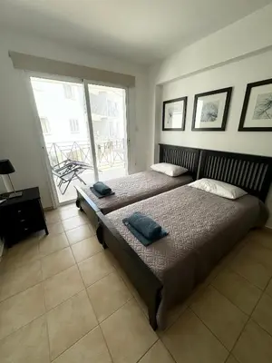 two beds in a room with two windows at Apartment Veronika in Paralimni