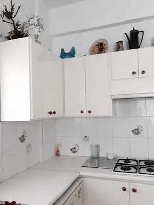 a white kitchen with white cabinets and a stove at Erini Villa in Protaras