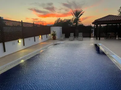 a swimming pool with a sunset in the background at Erini Villa in Protaras