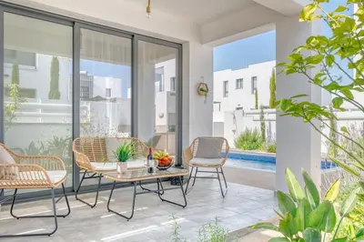 a patio with chairs and a table and some plants at Luxurious Villa Alasia in Paralimni in Paralimni