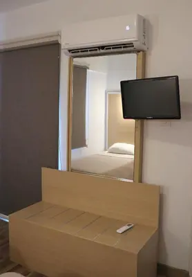 a room with a mirror and a tv and a bed at Layiotis Hotel in Larnaka