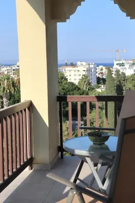 a balcony with a table and a view of the ocean at Layiotis Hotel in Larnaka