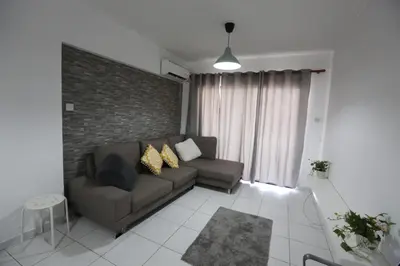 a living room with a couch and a brick wall at Near the Beach Holiday Apartment in Limassol