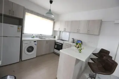 a white kitchen with a sink and a dishwasher at Near the Beach Holiday Apartment in Limassol