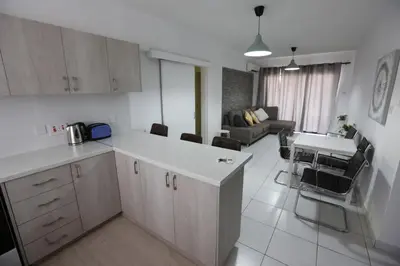 a kitchen and living room with a couch and a table at Near the Beach Holiday Apartment in Limassol