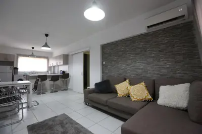 a living room with a couch and a brick wall at Near the Beach Holiday Apartment in Limassol