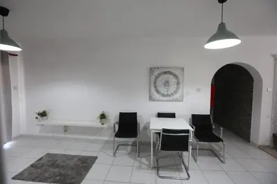 a dining room with a white table and black chairs at Near the Beach Holiday Apartment in Limassol