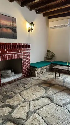 a patio with a brick fireplace and a green bench at Loucy’s Art Home in Mandria
