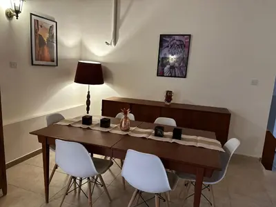 a dining room table with white chairs and a lamp at Loucy’s Art Home in Mandria