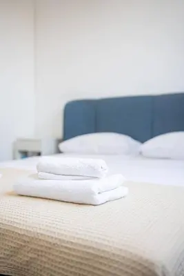 two white towels sitting on top of a bed at Hubstay Tamara Gardens 2 Bed Apt Suite with Pool in Livadhia