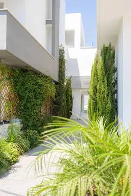 a building with plants on the side of it at Hubstay Tamara Gardens 2 Bed Apt Suite with Pool in Livadhia