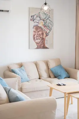 a living room with a couch and a painting on the wall at Hubstay Tamara Gardens 2 Bed Apt Suite with Pool in Livadhia