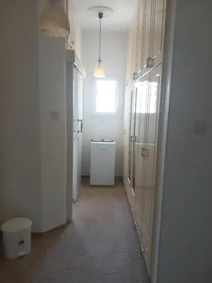 a hallway of a room with a sink and a window at Vasilis family room in Mor Menekshe