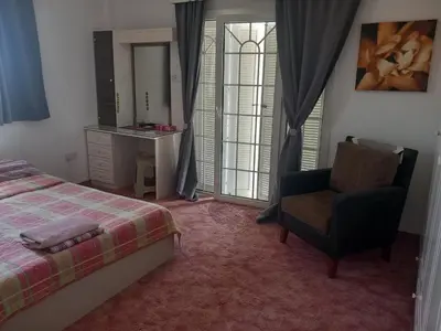 a bedroom with a bed and a chair and a desk at Vasilis family room in Mor Menekshe