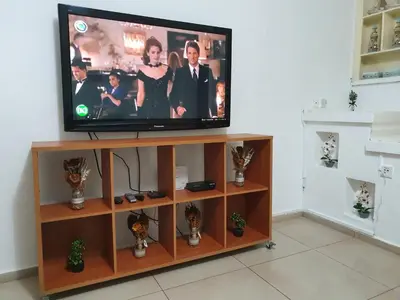 a flat screen tv sitting on top of a entertainment center at The Little House in Voroklini