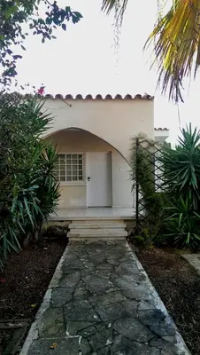 a house with a white door and a stone walkway at The Little House in Voroklini