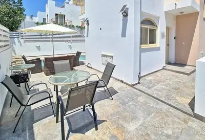 a patio with a table and chairs and an umbrella at La Villa in Paralimni