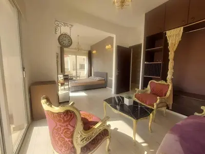 a living room with a table and chairs and a bedroom at Central 1 bedroom lux apartment in Larnaka